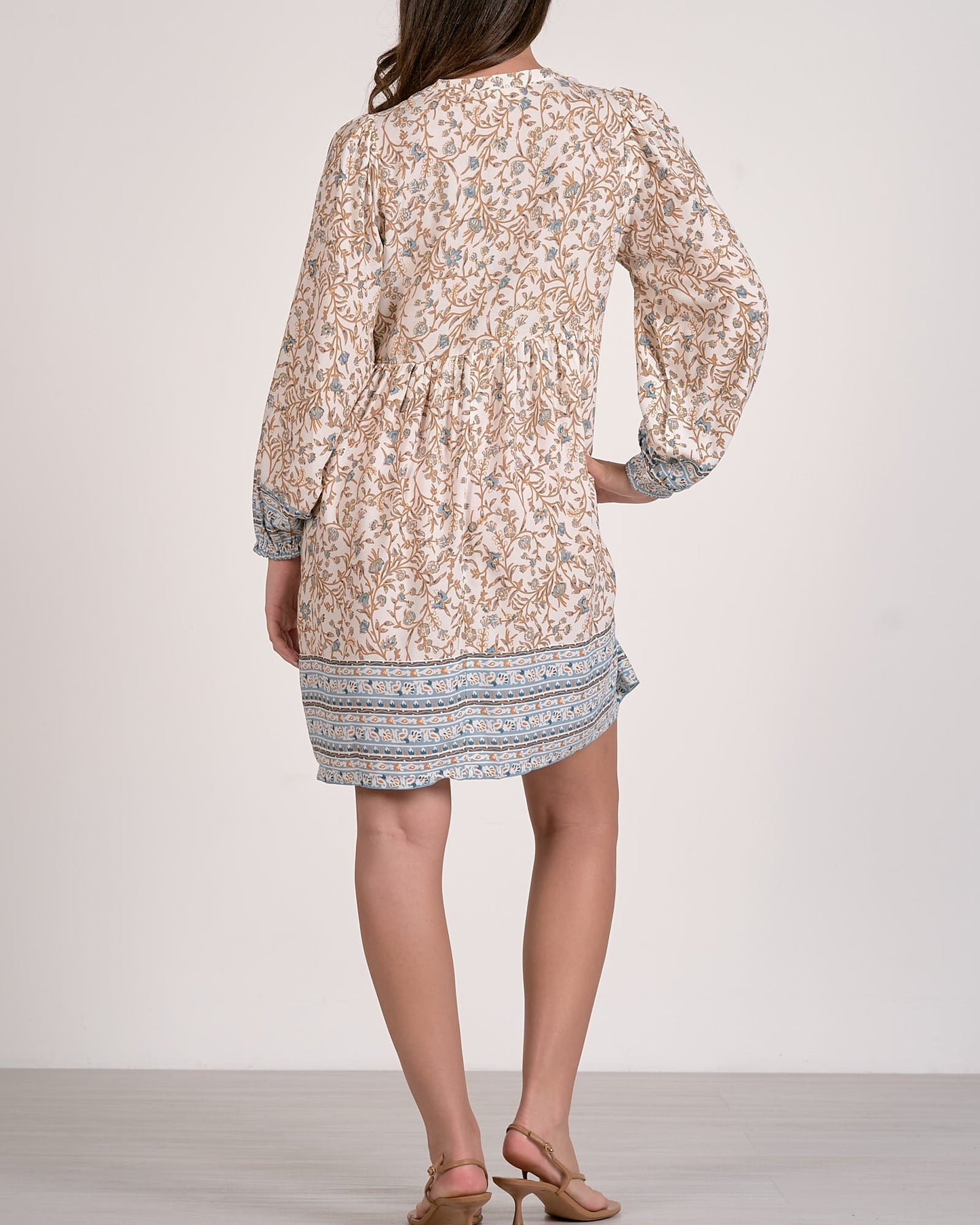 Woman wearing a floral dress with a plain background