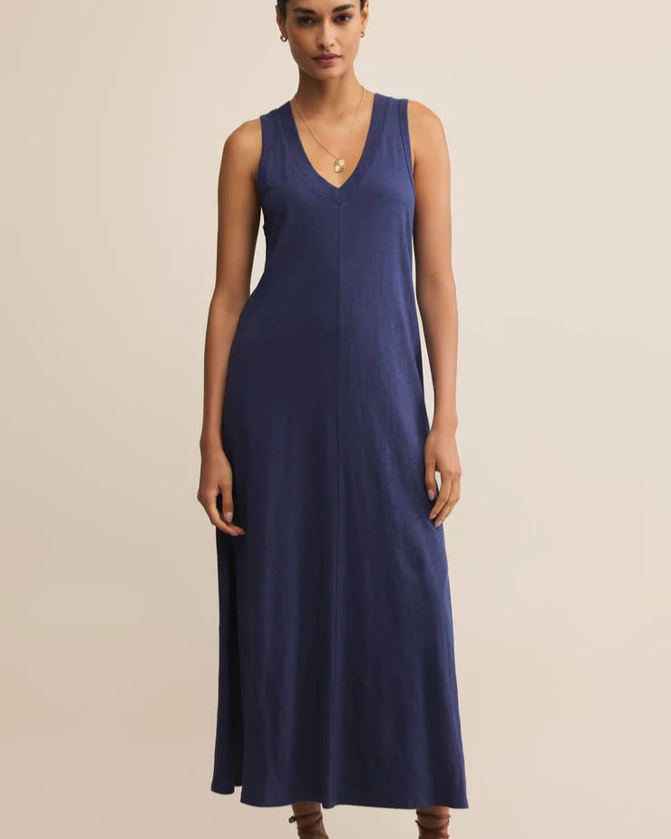 Woman wearing a blue sleeveless dress on a beige background