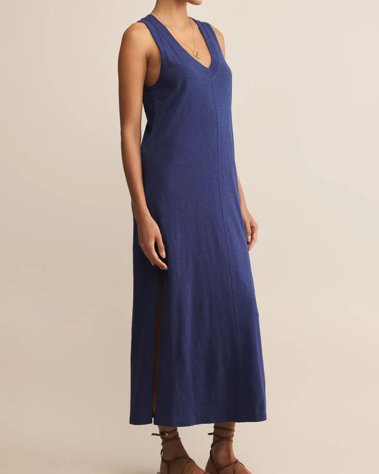 Woman wearing a blue sleeveless dress on a beige background