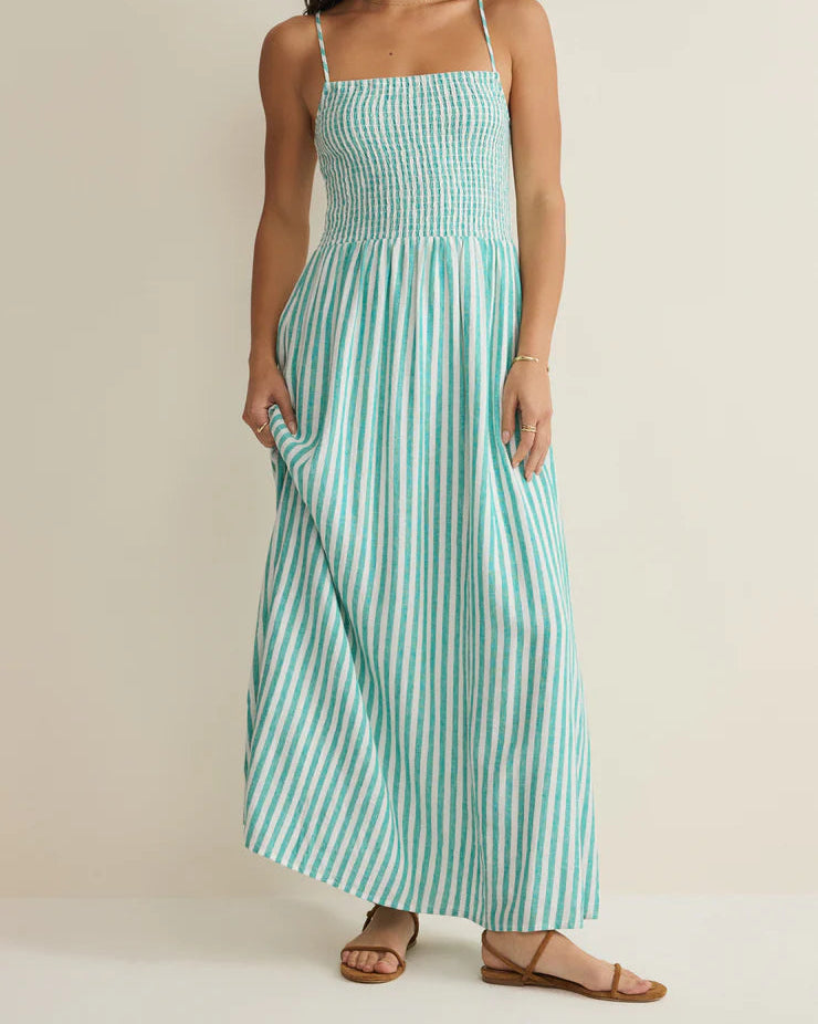 Woman wearing a green and white striped dress on a beige background