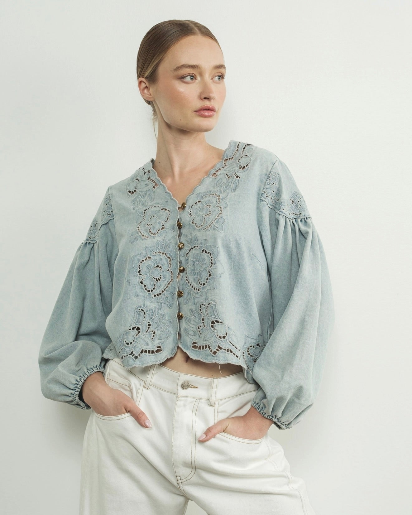 Aaron and amber denim floral embroidery blouse, woman wearing flower embroidered blouse, light blue in front of white wall puff sleeves, summery