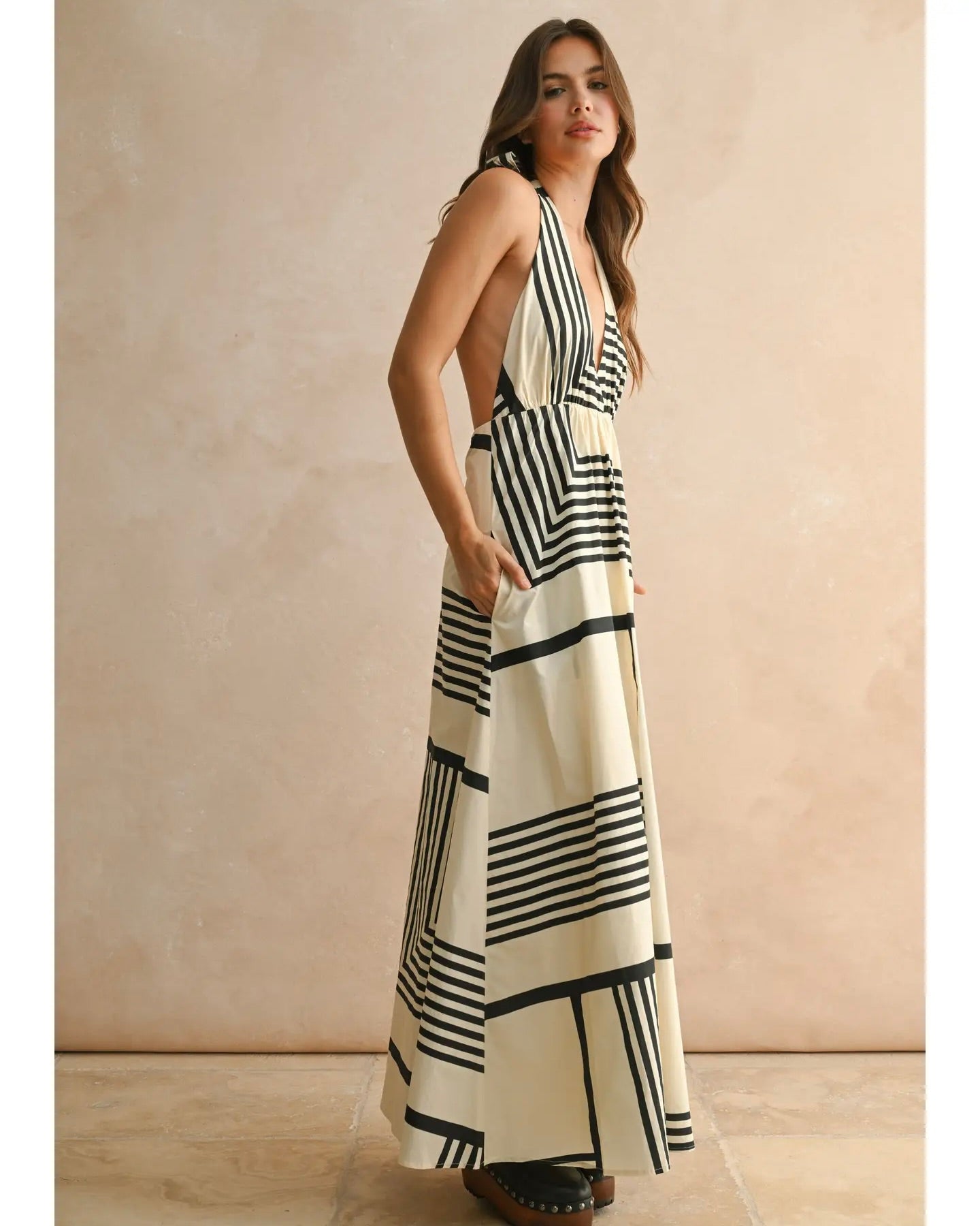 Model is wearing MIOU MUSE GEO Print Halter Dress on a beige background.