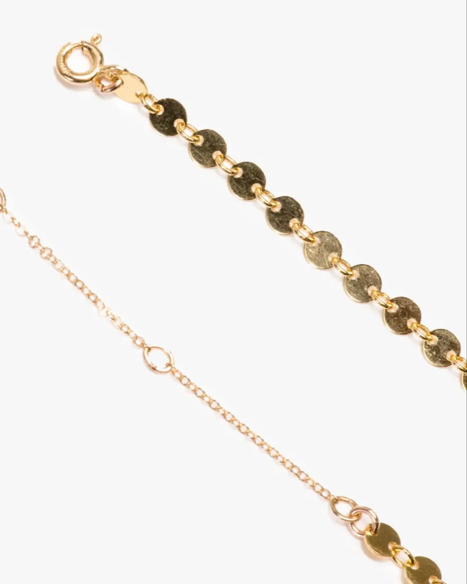 Close up photo of the Able Coin Chain Necklace in gold laying flat against a white background