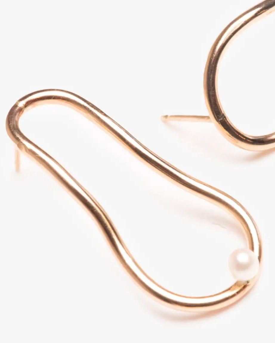 Close up photo of the Able Pearl Orbit Earrings laying flat against a white background
