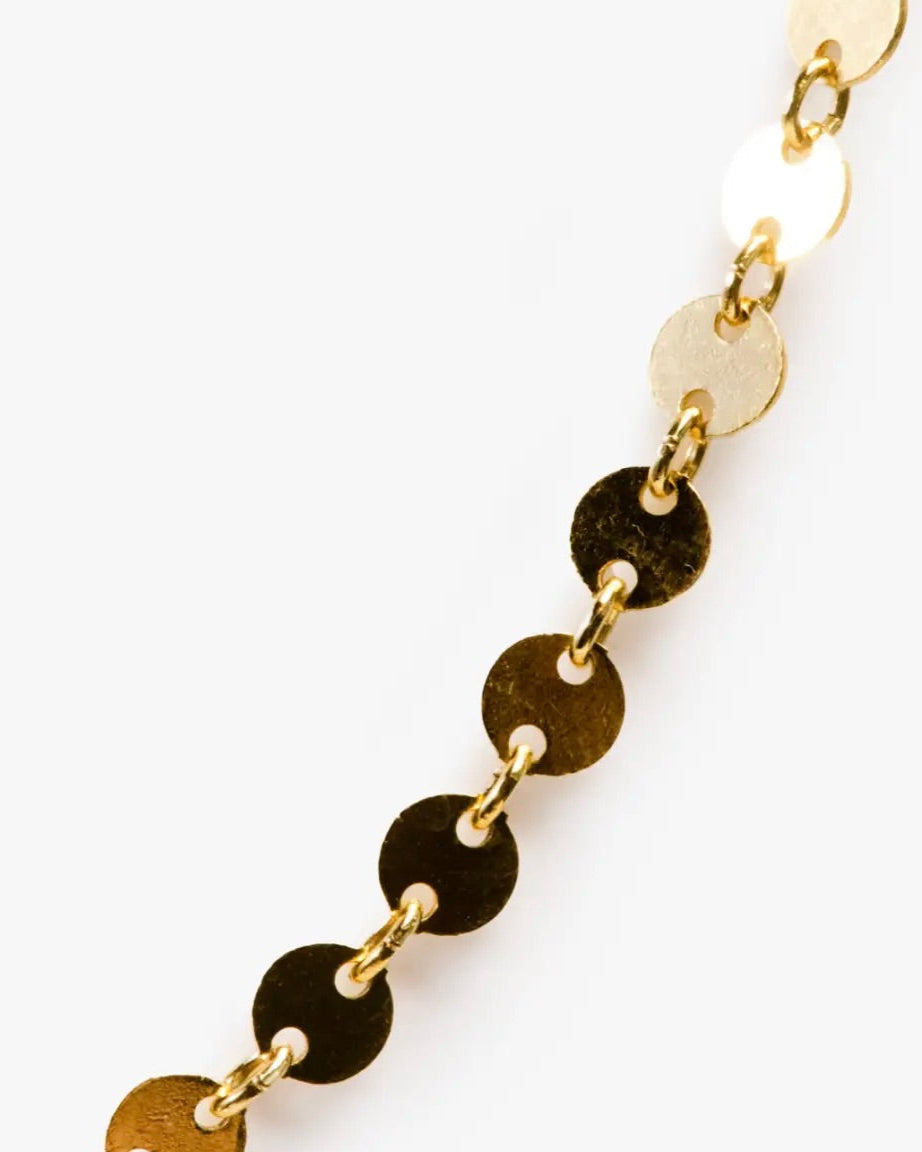 Close up photo of the Able Coin Chain Necklace in gold laying on a white background