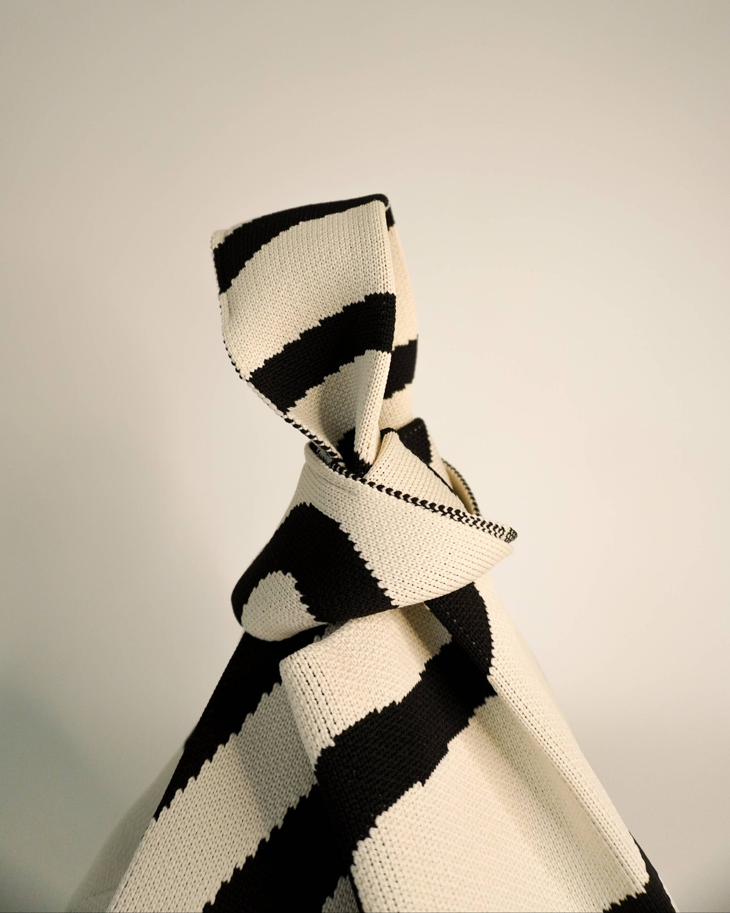 Black and white striped scarf on a neutral background