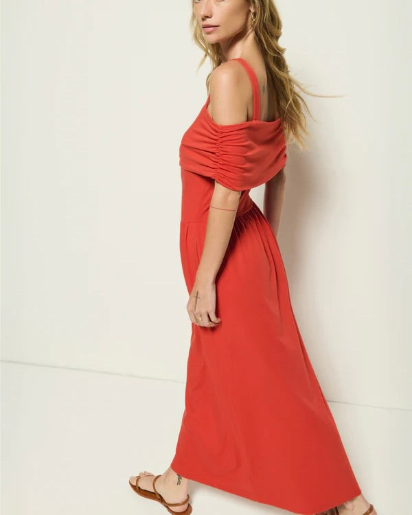 Side view of the Nation Tamaira Dress on a model posing in front of a white wall.