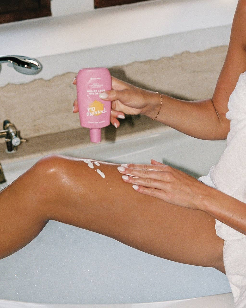 Person applying a product to their leg in a bathroom setting