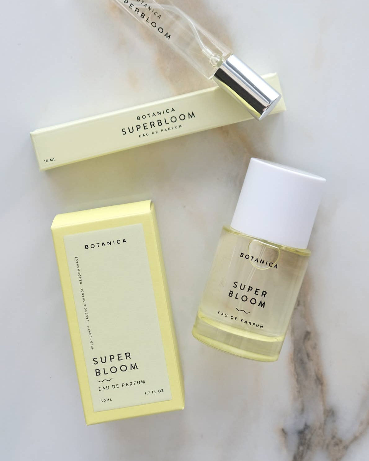 Botanica Super Bloom perfume bottle and packaging on a marble surface