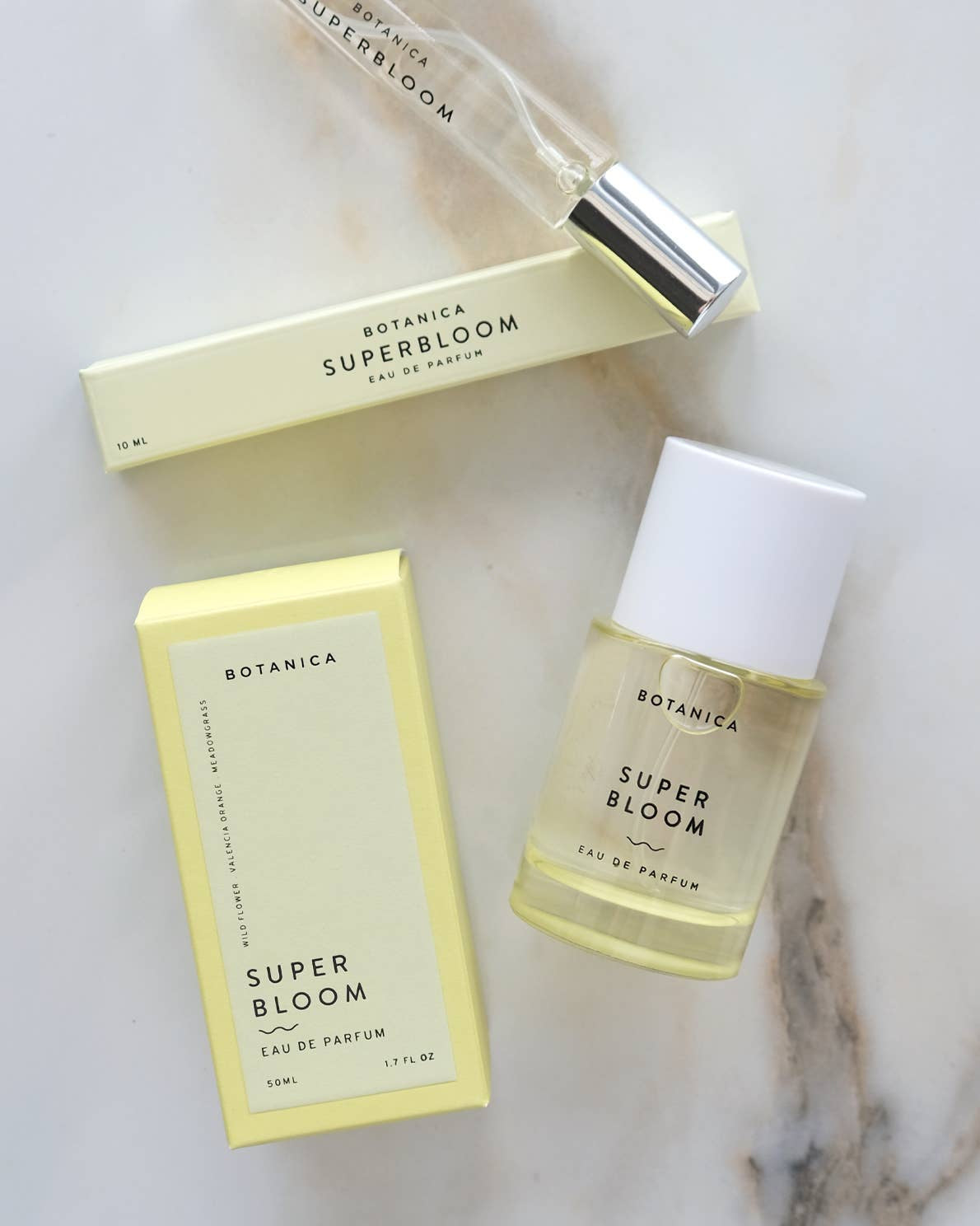 Botanica Super Bloom perfume bottle and packaging on a marble surface