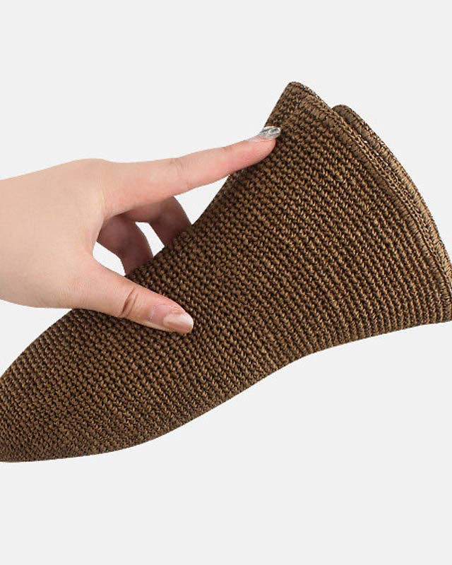 Brown shoe scrubber held by a hand on a white background
