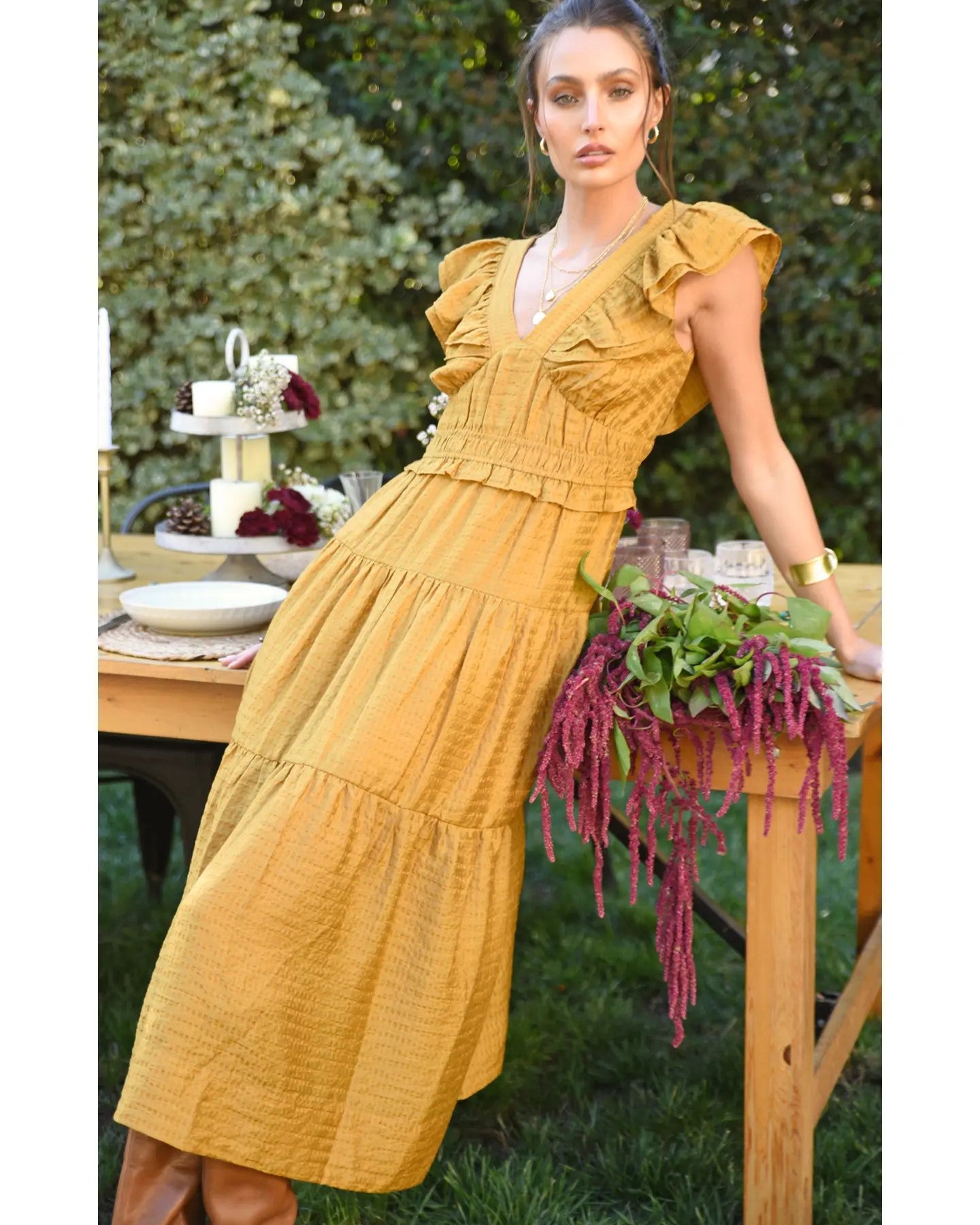 Model wearing Greylin Mustard Kalista Textured Midi Dress leaning against a table outside 