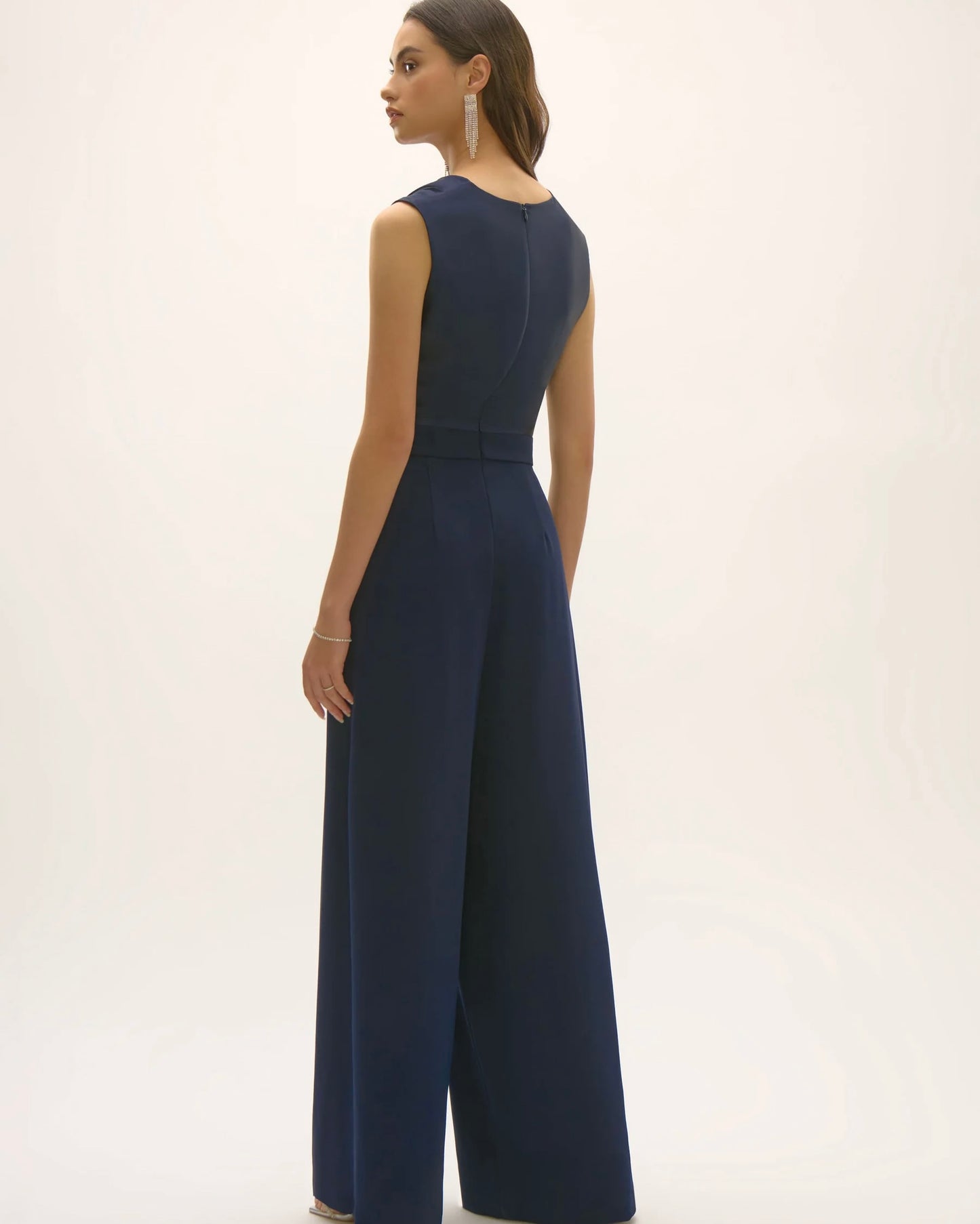 joseph ribkoff satin and crepe jumpsuit navy blue on model in front of white wall or background showing the back of jumpsuit