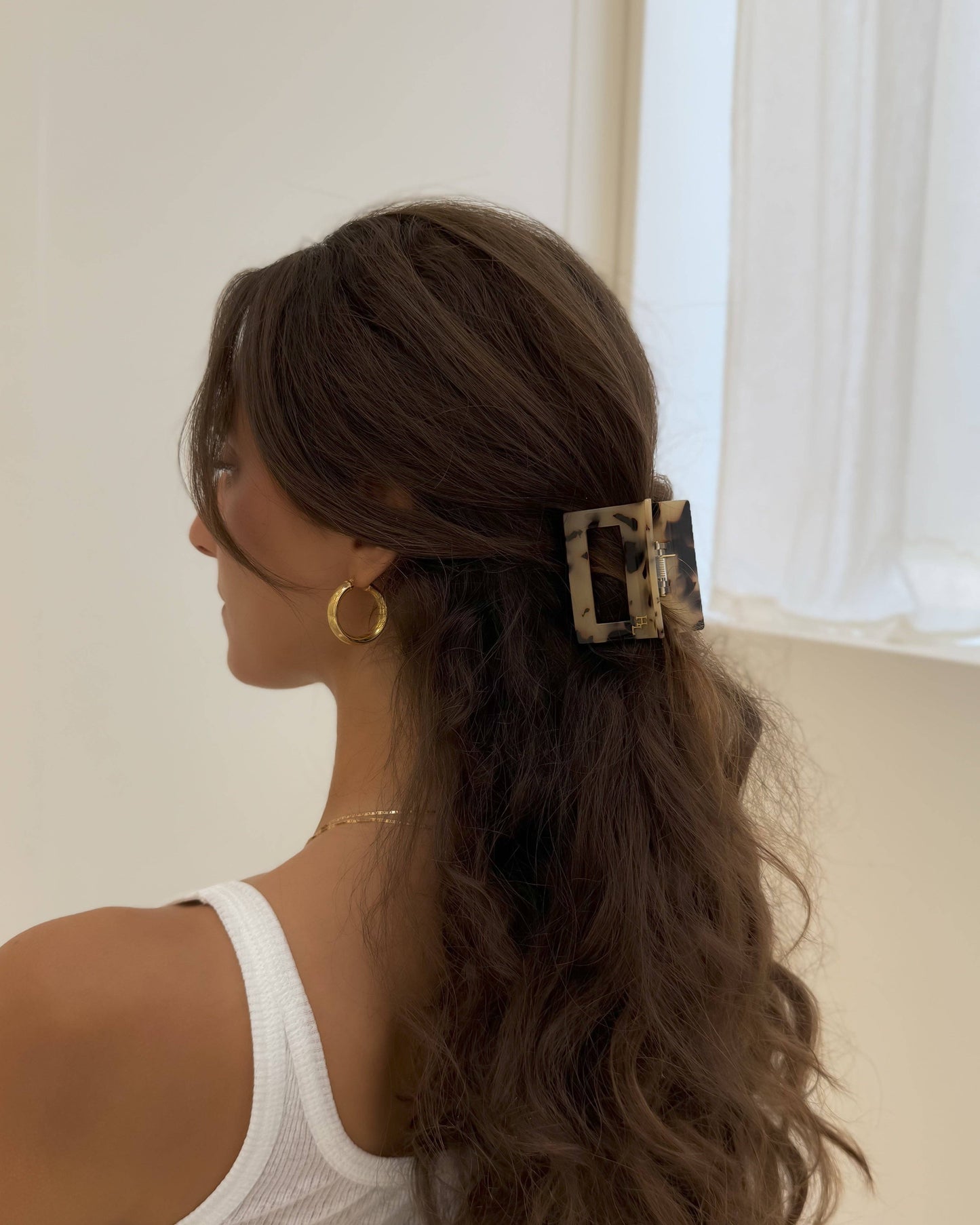 Woman with styled hair wearing the HoneyLux Dolce Large Acetate Claw clip in the color Classic Tortoise against a neutral background