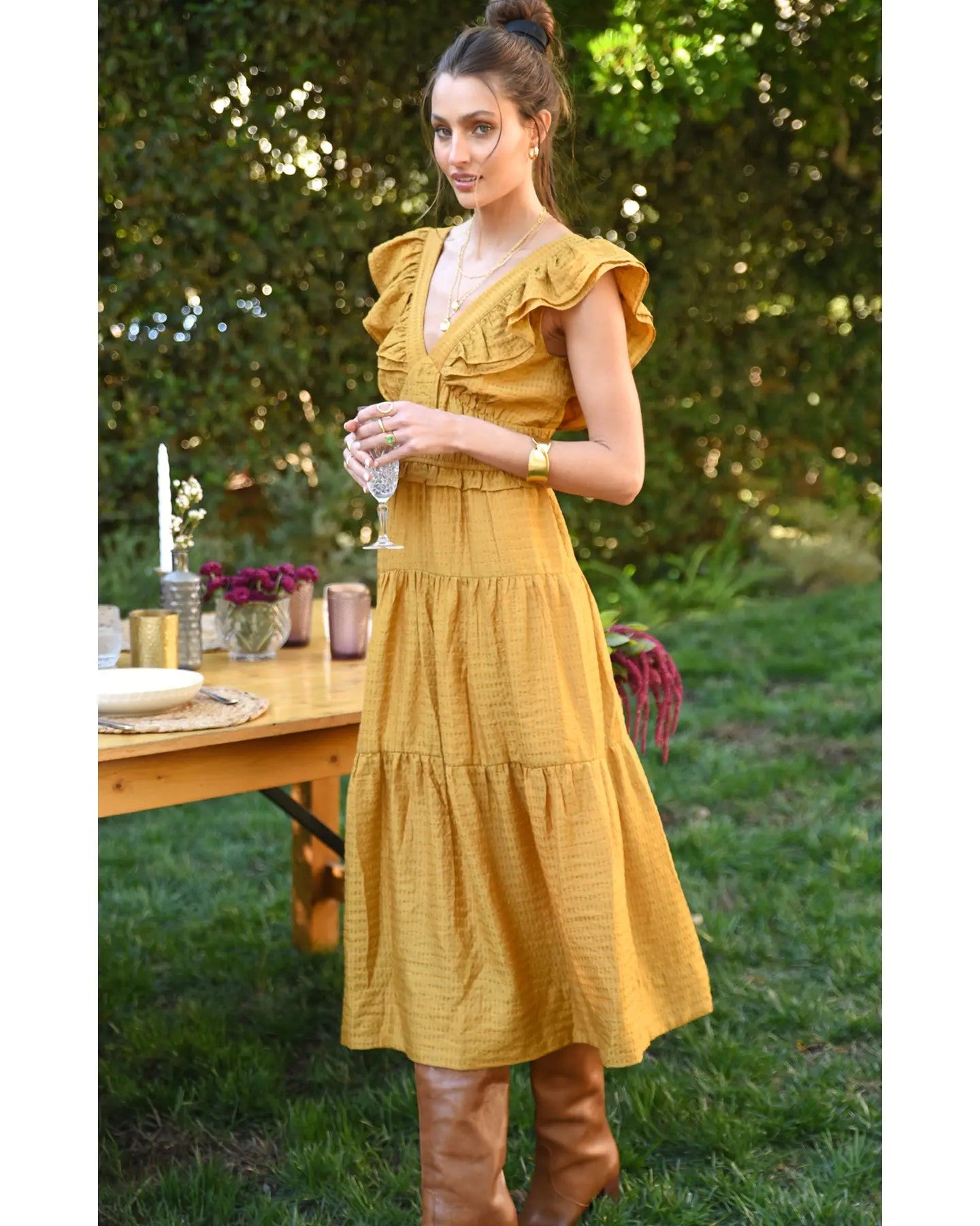 Model wearing Greylin Mustard Kalista Textured Midi Dress leaning against a table outside