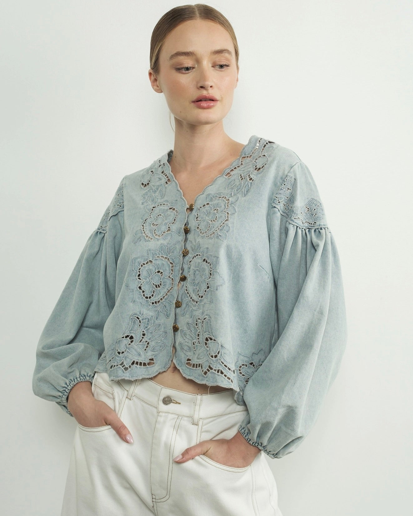 Aaron and amber denim floral embroidery blouse, woman wearing flower embroidered blouse, light blue in front of white wall puff sleeves, summer top