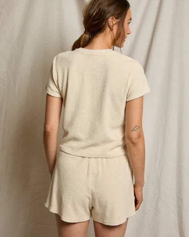 Woman wearing a beige outfit against a plain background