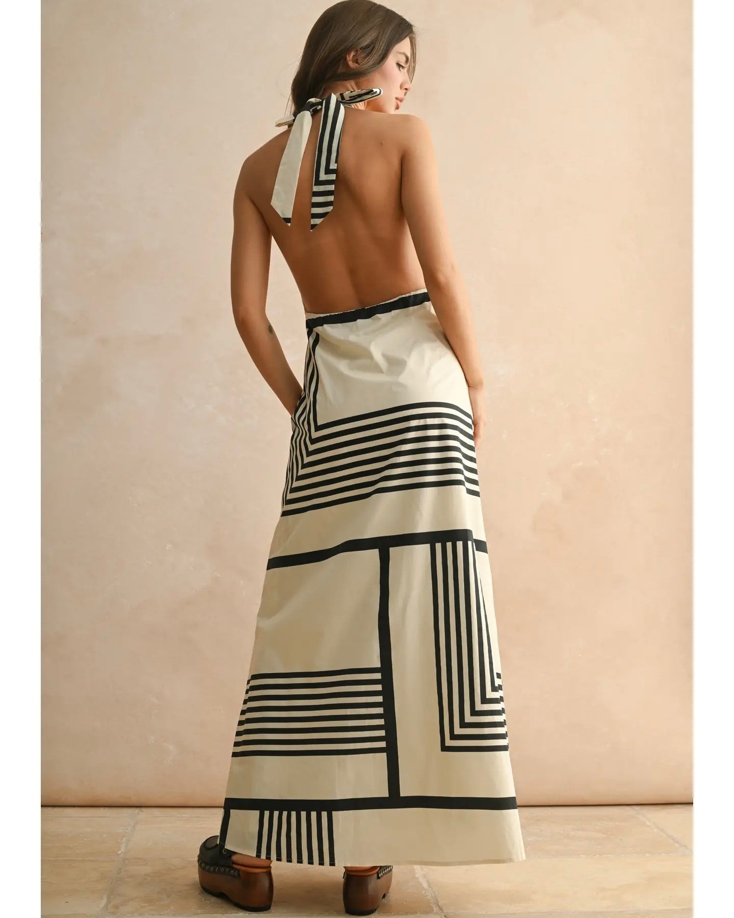 Model is wearing MIOU MUSE Geo Print Halter Dress on a beige background.