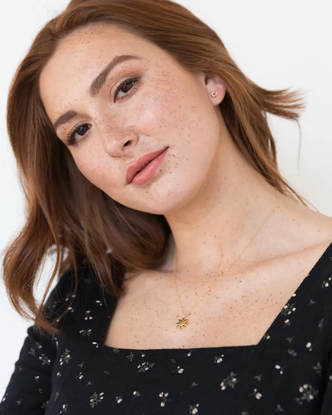 Photo of a model wearing the Able Evermore Stud Earrings in gold in front of a white background