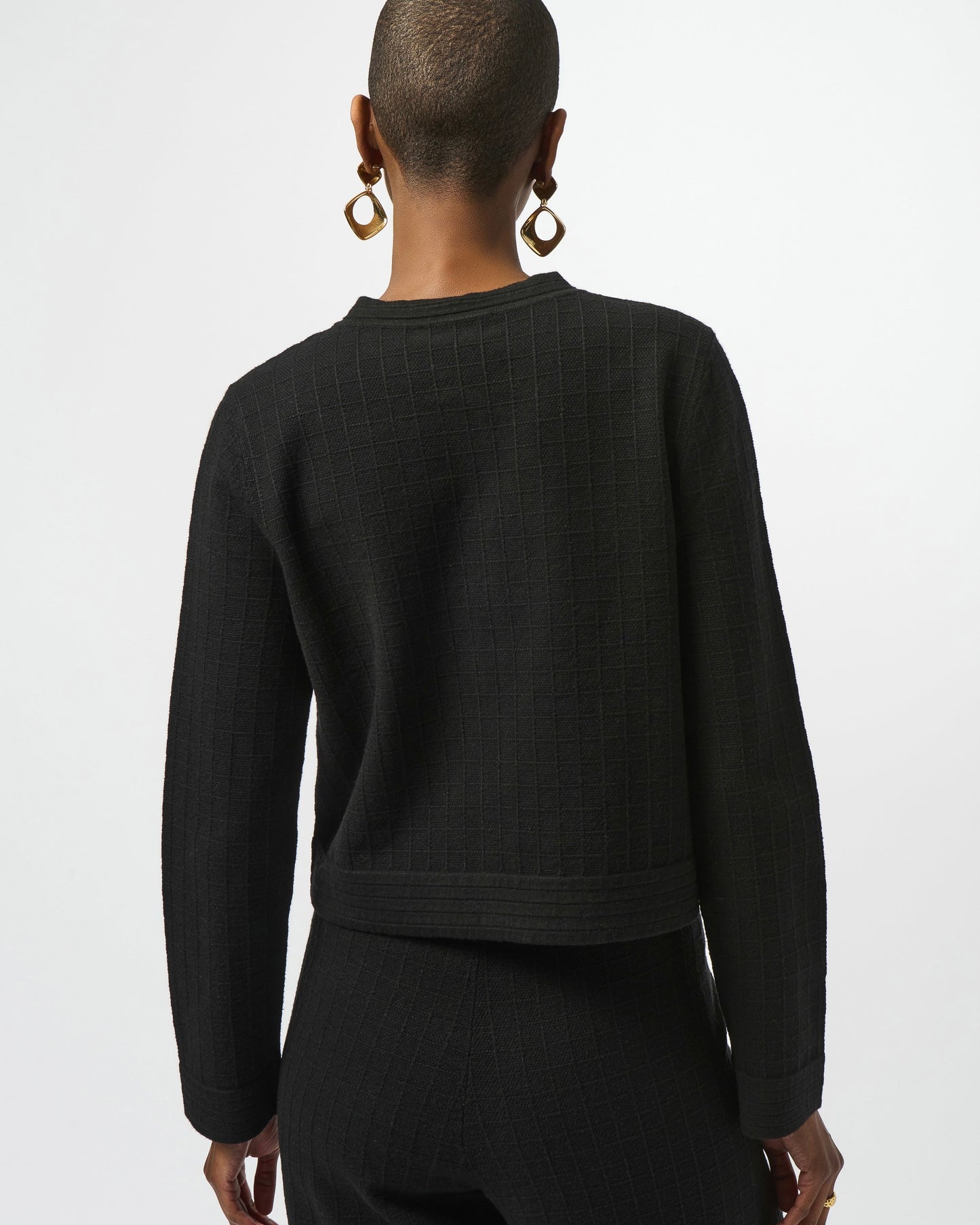 Model is wearing Joseph Ribkoff Sweater Knit Button Front Jacket in black with black knit pants on a white background