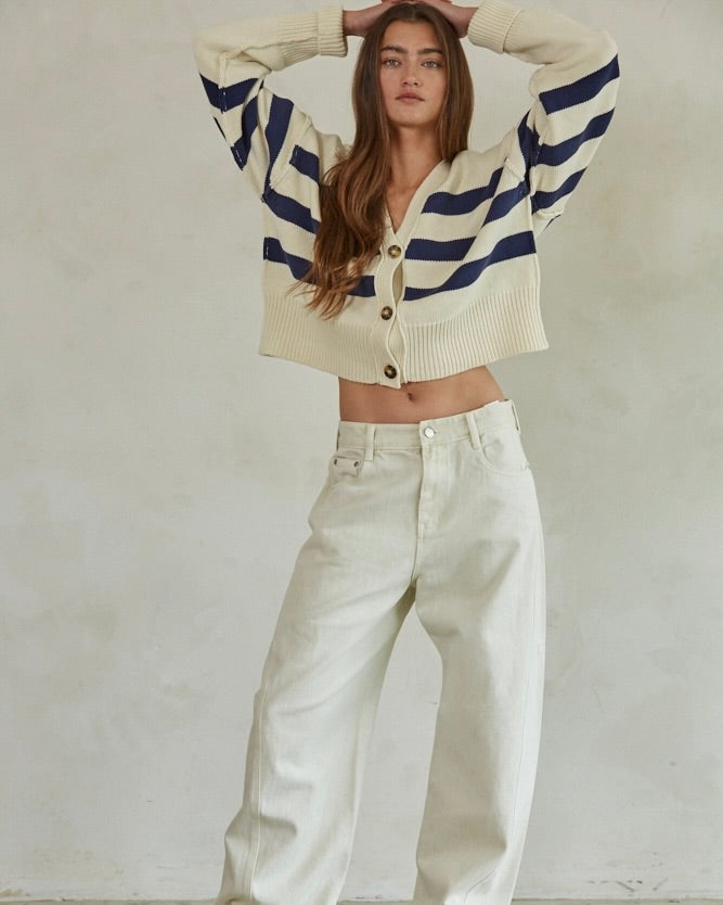 Front view of model wearing the By Together Knit Sweater Striped Button Down Cardigan posing against a beige wall