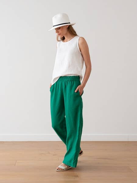 Model Wearing LinenMe Green Ruth Linen Trouser Pant Wearing White Linen Tank Top And A White Hat On A White BackGround