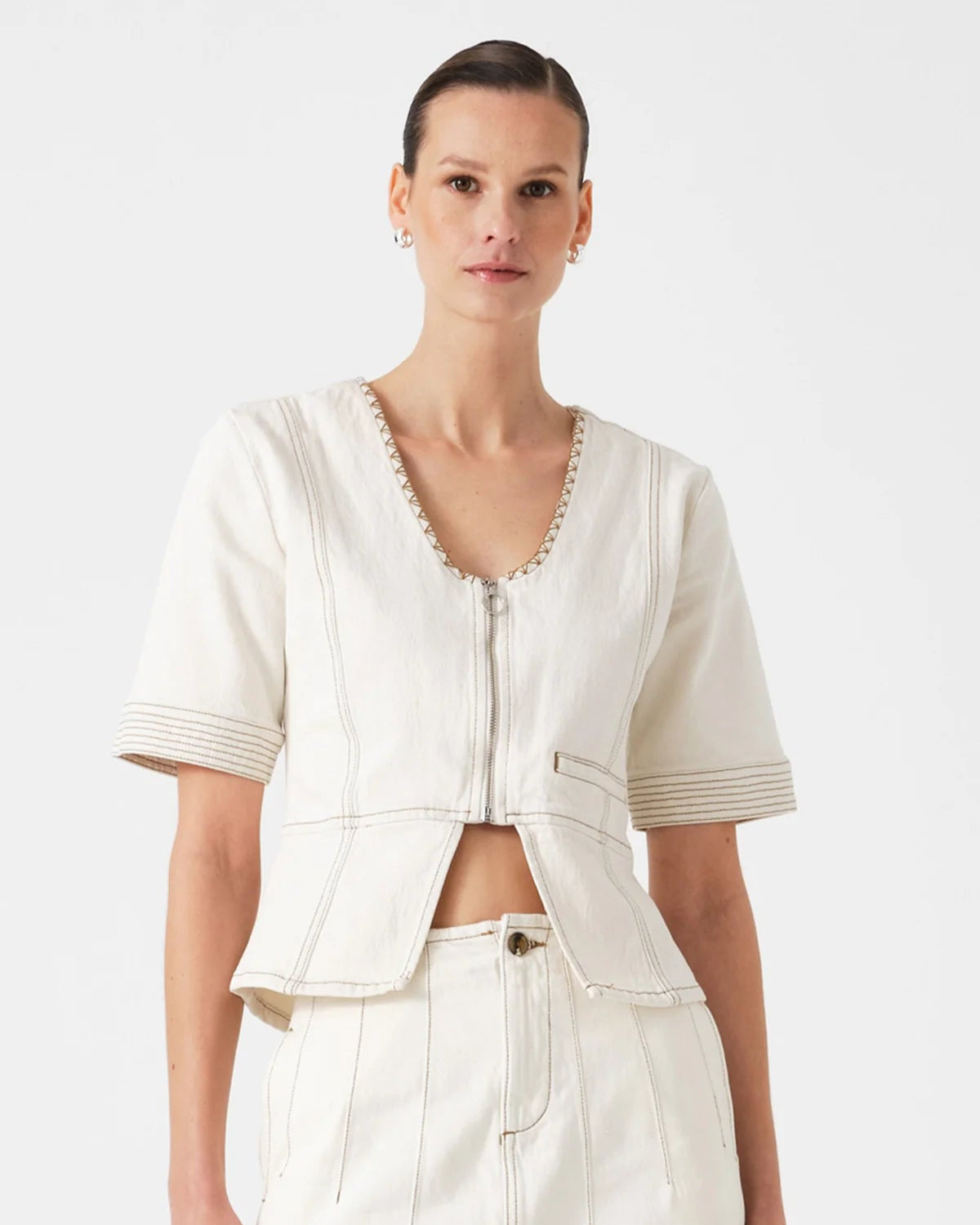 Woman wearing the seventy + mochi lea top in ecru with a on a plain background