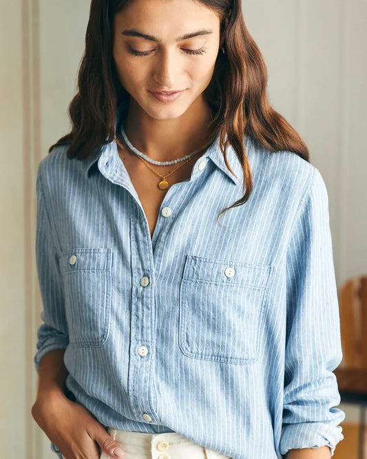 Model wearing Faherty Tried and True Chambray shirt standing in her house 