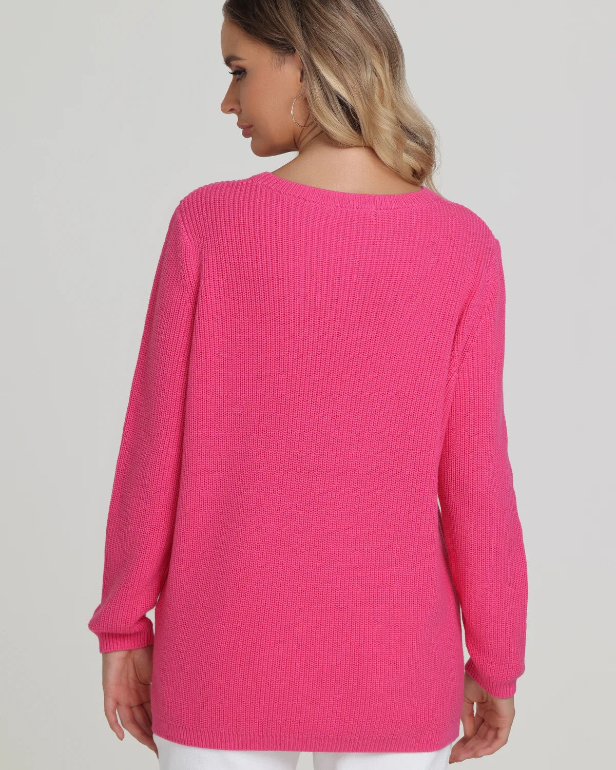 Model wearing 525 America Emma Crewneck Shaker Stitch Sweater in shocking pink color wearing white pants on a white background