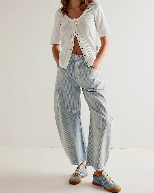 Model wearing Free People Good Luck Stripe Barrel Jeans in blue/white wearing a white shirt on a white background
