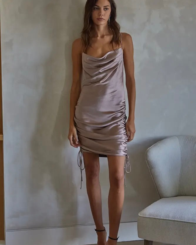 Model wearing By Together Satin Mini Dress in Mocha color standing behind a gray wall