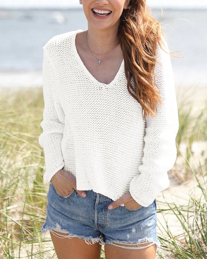 Model wearing Wooden Ships white cotton sweater wearing jean shorts at the beach