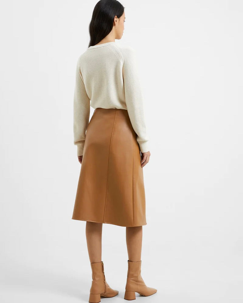 Model wearing French Connection Claudia PU Skirt in Camel wearing white shirt and boots on a white background