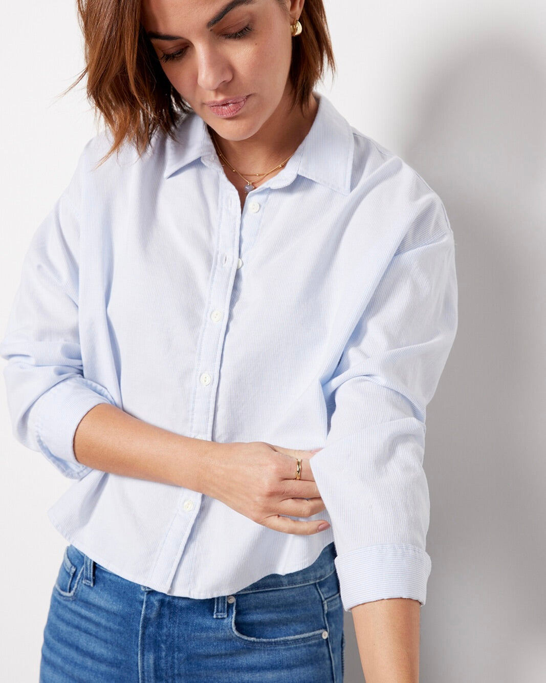 Model wearing Faherty Stretch Oxford Cropped Shirt wearing jeans on a white background