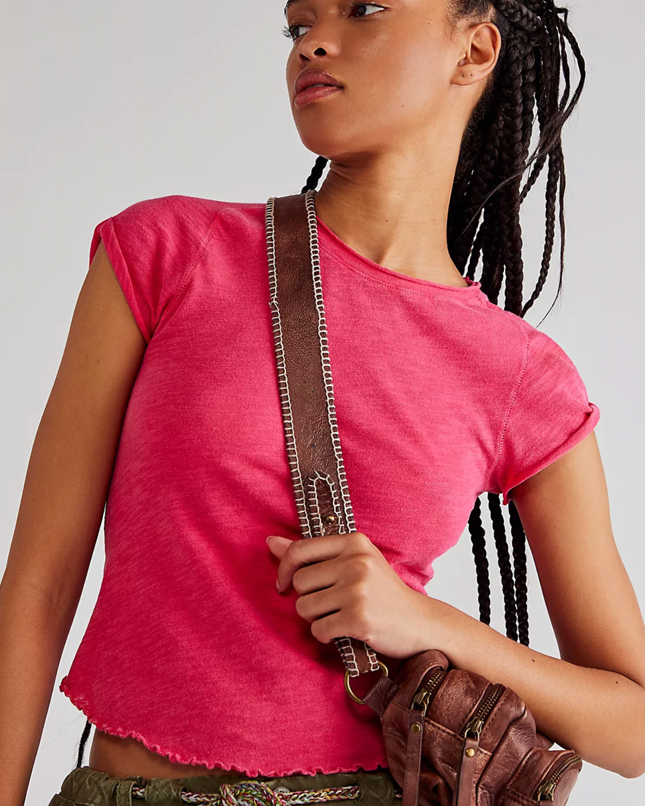 Model wearing Free People Be My Baby Tee in Strawberry color wearing a brown leather bag on a white background