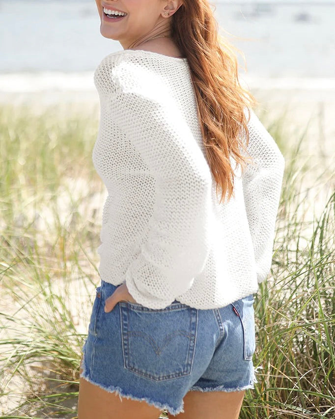 Model wearing Wooden Ships White Cotton Cropped Maui V Neck sweater wearing Jean Shorts On The Beach