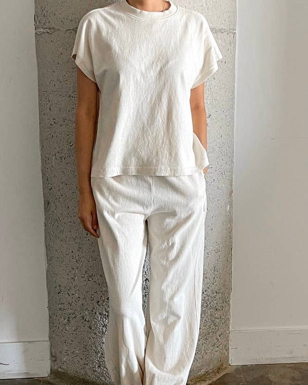 Model wearing Le Bon Shoppe-Jeanne Tee wearing white pants on a white background