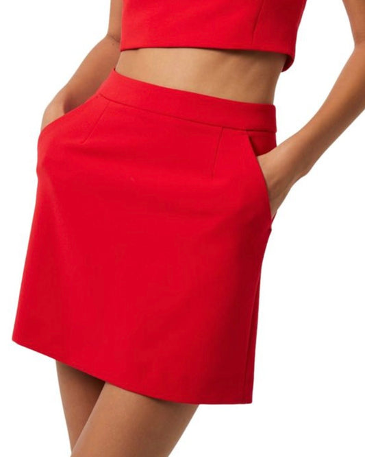 Model wearing French Connection Whisper Short Skirt in Royal Scarlett wearing a red shirt on a white background