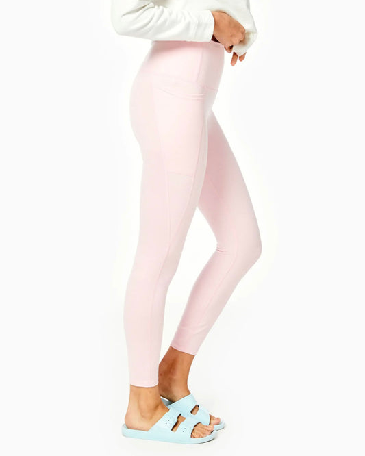 Model wearing Addison Bay Ludlow Leggings in heather pink wearing white shirt side view on a white background