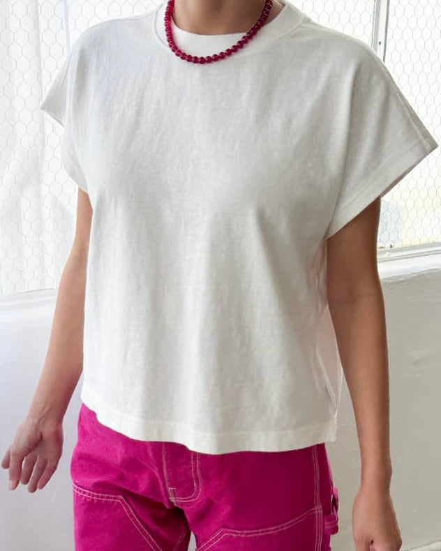 Model Wearing Le Bon Shoppe-Jeanne Tee in white wearing Pink pants and pink necklace on a white background