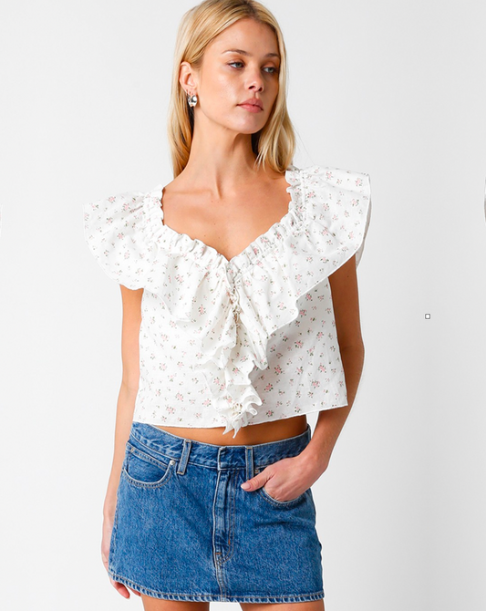 Model wearing Olivaceous Ditty Floral Ruffle V Neck wearing jean skirt on a white background