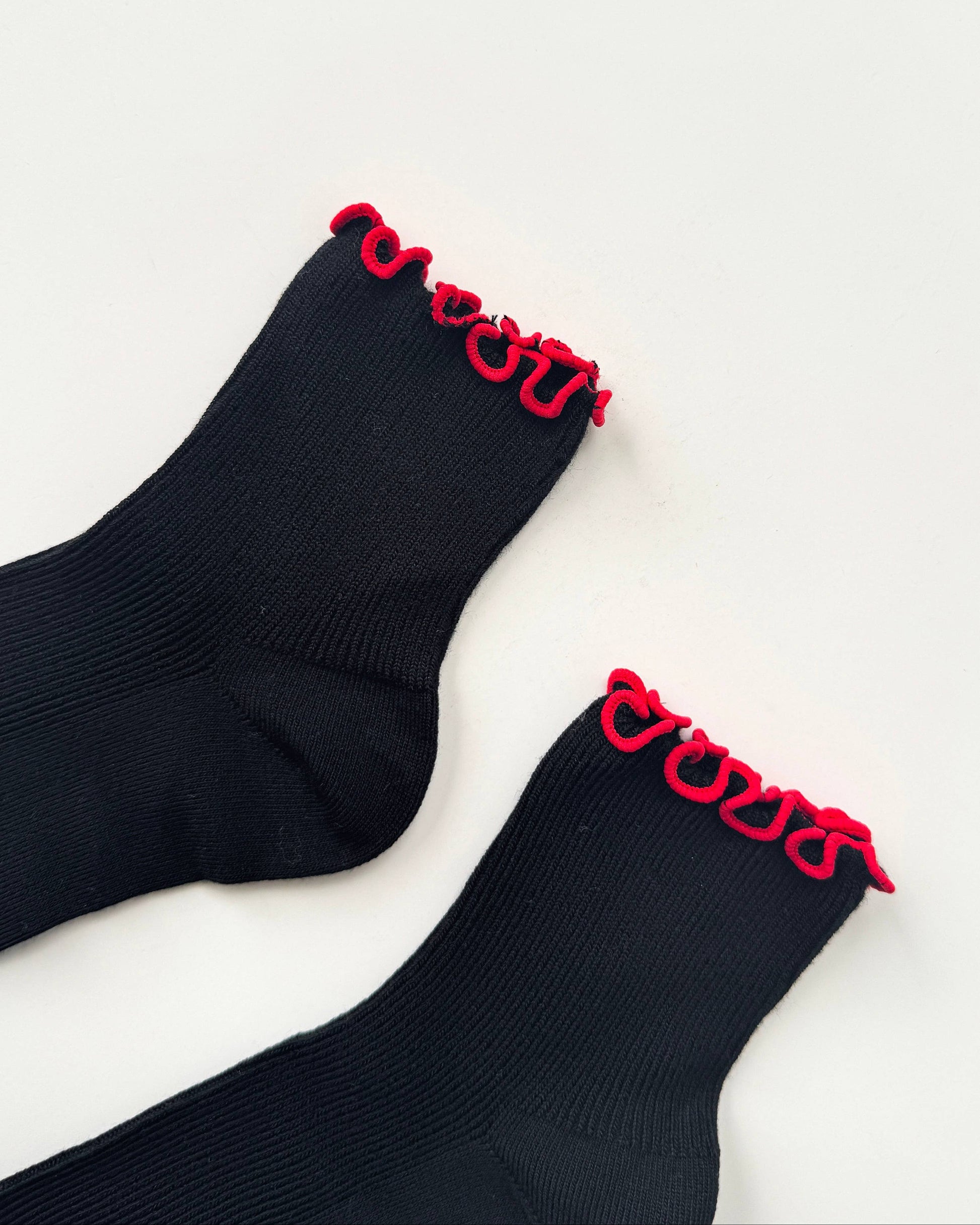 Black socks with red trim on a white background