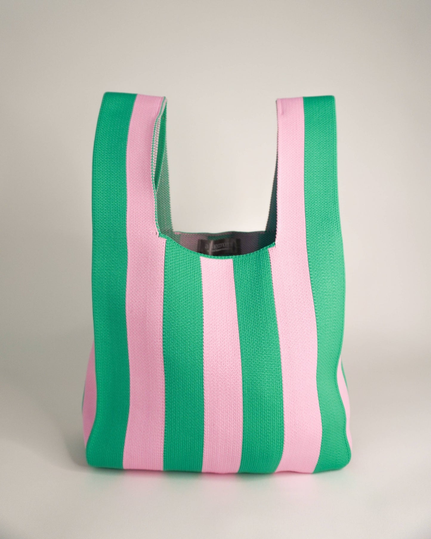 Striped green and pink bag on a light gray background