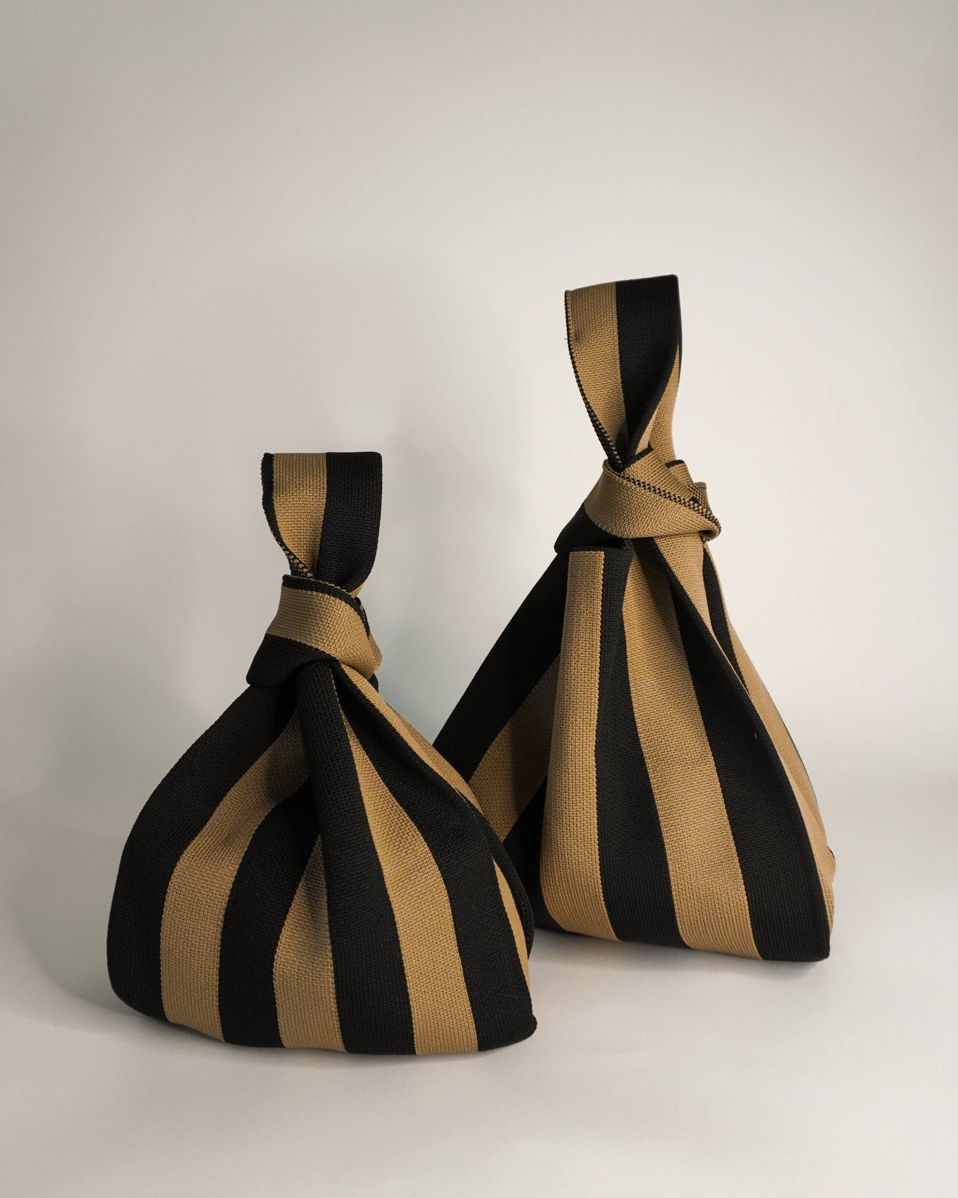 Two striped fabric bags with a knot on a white background