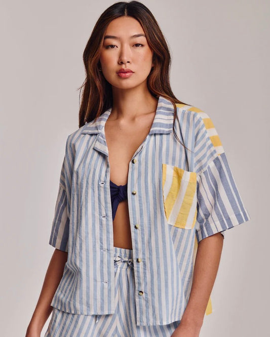 Woman wearing a striped shirt and pants set on a plain background