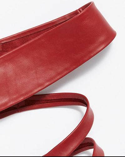 Red leather belt with a strap on a white background