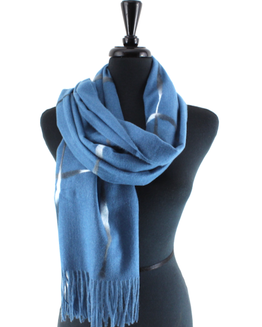 A blue scarf with a white windowpane plaid pattern and fringed ends, displayed on a black mannequin torso against a white background.