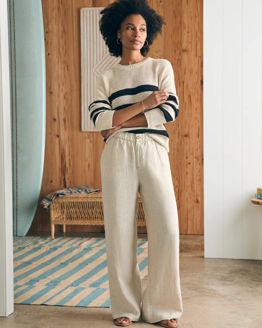 Model wearing Faherty Monterey Linen Pants wearing a white/navy sweater standing inside her house