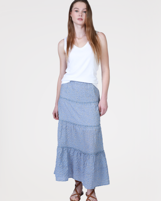 Model wearing Dylan Asher Maxi Skirt in Faded Blue wearing a white tank and brown sandals on a white background