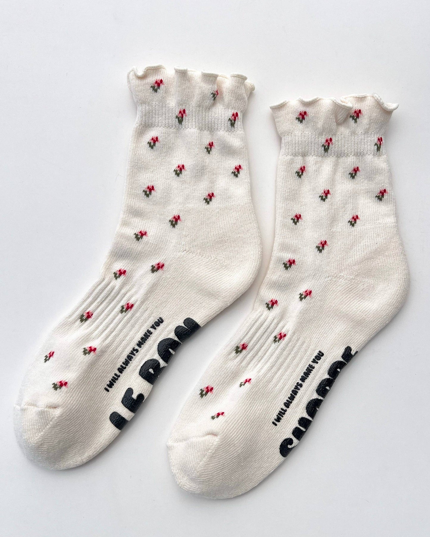 White socks with black paw prints and red hearts on a light gray background